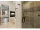 Shower with glass door, a glass block accent wall, and views to a fireplace and window at 2121 N Orchard --, Mesa, AZ 85213