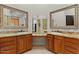 Bathroom with double vanity, granite countertop, wood cabinets, and large decorative mirrors at 2121 N Orchard --, Mesa, AZ 85213