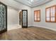 Empty bedroom featuring an iron doorway, wooden shutters, and hardwood floors at 2121 N Orchard --, Mesa, AZ 85213