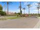 The Hermosa Estates community entrance, featuring mature palm trees, a brick sign, and a gated entrance at 2121 N Orchard --, Mesa, AZ 85213