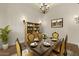 Traditional dining room with dark table, yellow upholstered chairs, and classic chandelier at 2121 N Orchard --, Mesa, AZ 85213