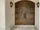 Detailed view of the impressive wooden double doors with wrought iron hardware, adding a touch of rustic charm at 2121 N Orchard --, Mesa, AZ 85213