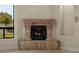 Living room with a decorative stone fireplace and view of the landscaped yard at 2121 N Orchard --, Mesa, AZ 85213