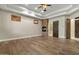 Large main bedroom featuring hardwood floors, stone fireplace, tray ceilings, and wooden doors at 2121 N Orchard --, Mesa, AZ 85213