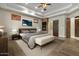 Main bedroom with a stone fireplace, tray ceiling, hardwood floors, and access to the en suite bathroom at 2121 N Orchard --, Mesa, AZ 85213