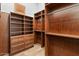 Walk-in closet with custom wood shelves, cabinets, and drawers for ample storage at 2121 N Orchard --, Mesa, AZ 85213