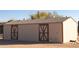 Large tan storage shed with double barn doors in a rural setting at 35852 N 10Th St, Phoenix, AZ 85086