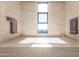 Bathroom with a large soaking tub, window with a view, and beige stone tile at 4060 E Lamar Rd, Paradise Valley, AZ 85253