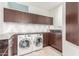 Modern laundry room with LG washer and dryer, granite countertops, and dark wood cabinets at 4060 E Lamar Rd, Paradise Valley, AZ 85253