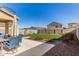 Lush backyard with green grass, a patio dining set and desert landscaping at 4488 W Charlie Dr, San Tan Valley, AZ 85144