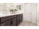 Modern bathroom featuring double sinks, dark cabinetry, white countertops, and wood-style floors at 4488 W Charlie Dr, San Tan Valley, AZ 85144