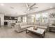 Bright living room featuring a large sectional sofa, decorative ceiling fan, and modern accents at 4488 W Charlie Dr, San Tan Valley, AZ 85144