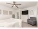 Spacious main bedroom with a ceiling fan, accent decor, and a comfortable gray chair at 4488 W Charlie Dr, San Tan Valley, AZ 85144