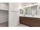 Bright bathroom features a double sink vanity, large mirror, and a view of the walk-in closet at 18544 E Dario Rd, Gold Canyon, AZ 85118