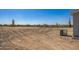 Picture shows the backyard, desert landscape with various cacti in the background at 41735 N 260Th Ave, Morristown, AZ 85342