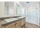 This bright bathroom features a double sink vanity and a glass enclosed shower at 41735 N 260Th Ave, Morristown, AZ 85342