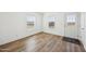 Bedroom with luxury vinyl plank flooring, two windows and an exterior door at 41735 N 260Th Ave, Morristown, AZ 85342