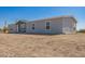 Home's exterior with gray siding surrounded by desert landscape and blue sky at 41735 N 260Th Ave, Morristown, AZ 85342
