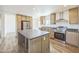 Modern kitchen featuring stainless appliances, light wood cabinetry, and a dark gray center island at 41735 N 260Th Ave, Morristown, AZ 85342