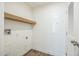 Bright laundry area boasts wood-look floors, a shelf, and a white door at 41735 N 260Th Ave, Morristown, AZ 85342