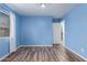 Light blue bedroom with wood-look floors and access to laundry at 8549 W El Caminito Dr, Peoria, AZ 85345