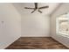 Bedroom featuring wood-look floors, ceiling fan, and bright window at 8549 W El Caminito Dr, Peoria, AZ 85345