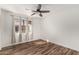 Bedroom with ceiling fan, wood-look floors, window with drapes, and a view to the street at 8549 W El Caminito Dr, Peoria, AZ 85345