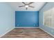 Light blue bedroom with wood-look floors, ceiling fan, and window coverings at 8549 W El Caminito Dr, Peoria, AZ 85345