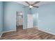 Bedroom with light blue walls, wood-look floors, and access to bathroom at 8549 W El Caminito Dr, Peoria, AZ 85345