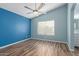 Bedroom with wood-look floors and blue accent wall at 8549 W El Caminito Dr, Peoria, AZ 85345