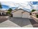 Two-car garage, light-colored exterior, landscaping at 8549 W El Caminito Dr, Peoria, AZ 85345