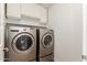 Laundry room with a front-load washer and dryer and upper cabinets at 8549 W El Caminito Dr, Peoria, AZ 85345