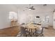 Bright open-concept living area featuring a ceiling fan, white sofas, and a round dining table with seating at 8549 W El Caminito Dr, Peoria, AZ 85345