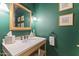 Elegant powder room with dark green walls and a wooden vanity at 14 E 14Th St, Tempe, AZ 85281