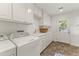 Clean laundry room featuring white cabinets and a utility sink at 14 E 14Th St, Tempe, AZ 85281