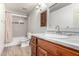 Bathroom with tile shower, wood cabinets, and modern fixtures at 15912 W Marconi Ave, Surprise, AZ 85374