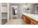 Open main bathroom featuring double sinks, tile flooring, and entry to a walk in closet at 15912 W Marconi Ave, Surprise, AZ 85374