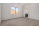 Bright, carpeted bedroom with a large window offering plenty of natural light at 17586 W Blue Sky Dr, Surprise, AZ 85387