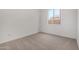 Bedroom featuring neutral carpet, bright white walls, and a window at 17586 W Blue Sky Dr, Surprise, AZ 85387