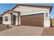 Newly constructed single-story home with a two-car garage and brick paved driveway at 17586 W Blue Sky Dr, Surprise, AZ 85387