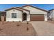 Inviting single-story home with brick driveway, arched entryway, and desert landscape at 17586 W Blue Sky Dr, Surprise, AZ 85387