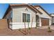 Home exterior featuring an attached garage, desert-style landscaping, and a cozy front porch at 17586 W Blue Sky Dr, Surprise, AZ 85387