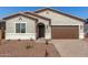 Beautiful house showcasing desert landscaping, an arched doorway, and a two-car garage at 17586 W Blue Sky Dr, Surprise, AZ 85387