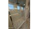 Beautiful tile surround in glass enclosed walk-in shower features pebble floor and a built-in seat at 17826 W Straight Arrow Ln, Surprise, AZ 85387