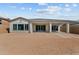 Back view of a single-story home with a covered patio and sliding glass doors to the backyard at 21627 W Mariposa St, Buckeye, AZ 85396