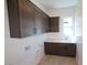 Well-lit laundry room with built-in cabinets, ample counter space, and modern fixtures at 21627 W Mariposa St, Buckeye, AZ 85396