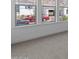 Bright living room featuring neutral decor, a large bank of windows, and plush carpeting at 21627 W Mariposa St, Buckeye, AZ 85396