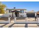 Remodeled home with a white brick facade, black garage door, and a landscaped front yard at 4315 E Nancy Ln, Phoenix, AZ 85042