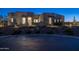 Stunning desert contemporary home with a stone facade and landscaped yard at twilight at 17213 E Morning Vista Ct, Rio Verde, AZ 85263