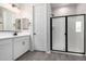 Contemporary bathroom featuring a sleek glass-enclosed shower, modern fixtures, and a tile floor at 17868 W Blue Sky Dr, Surprise, AZ 85387